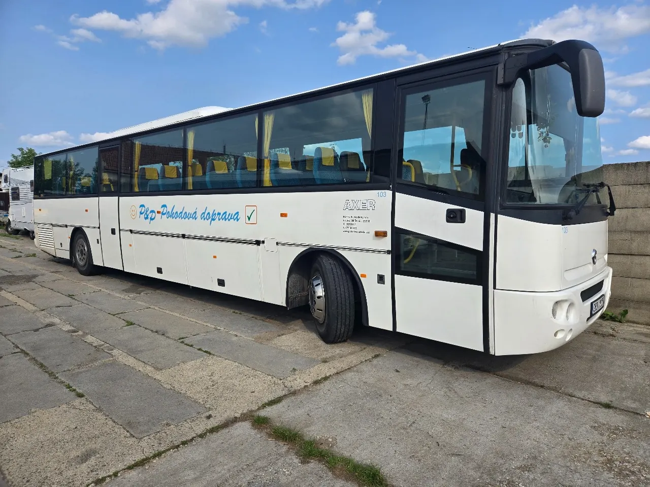 Bílý autobus Irisbus Axer s nápisem P&P Pohodová doprava na betonové ploše