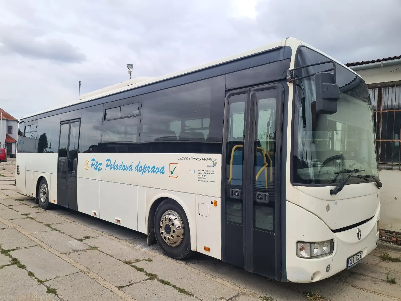 Bílý autobus Irisbus Crossway s nápisem P&P Pohodová doprava před halou